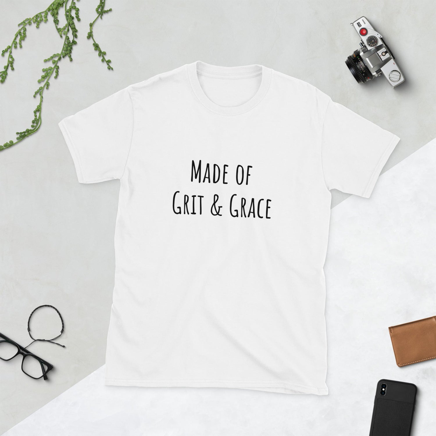 a collection of nurse-themed street clothes for nurses including t shirts and sweatshirts. shown is a white t shirt with black lettering that says made of grit and grace